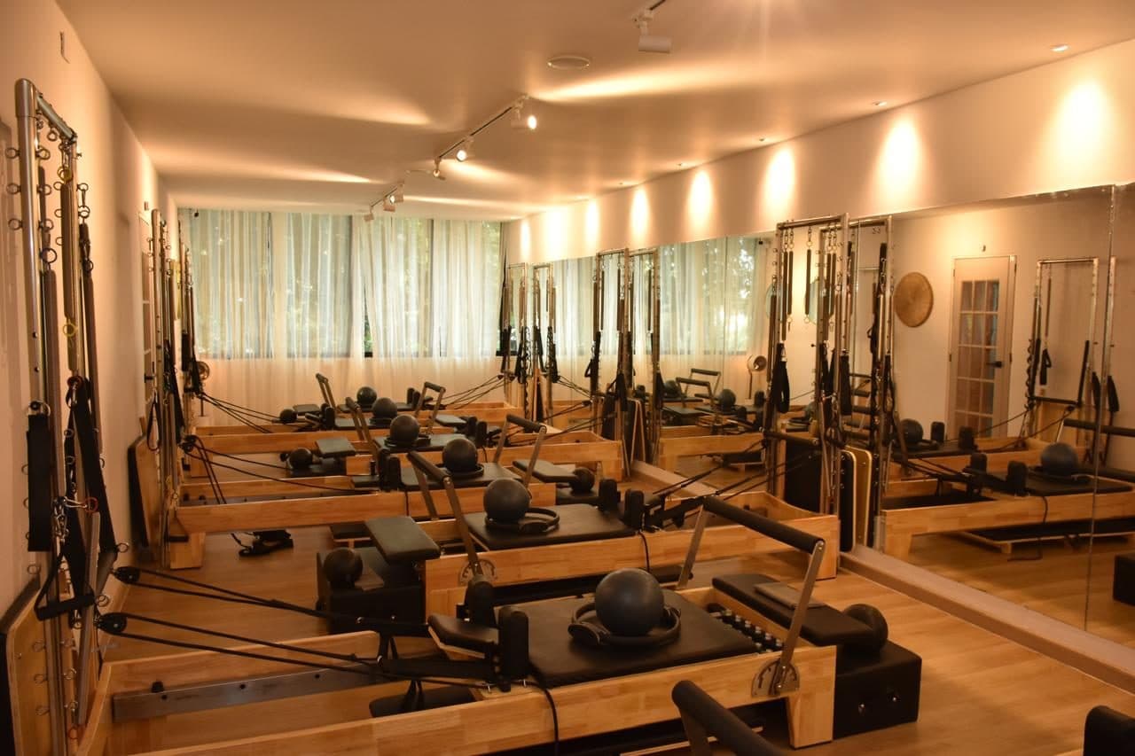 Sala amplia de pilates reformer con espejos